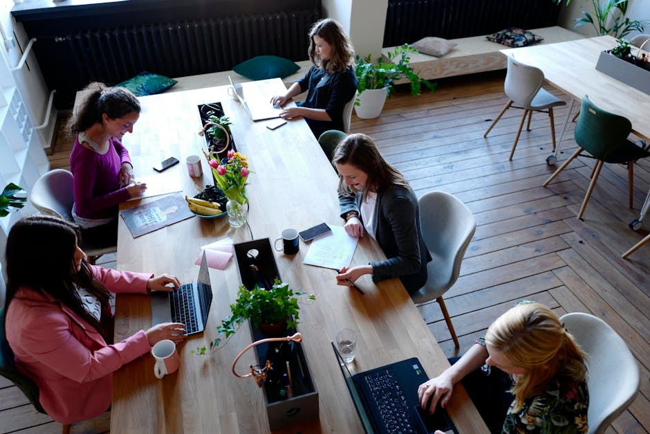 Small group of SaaS customers in a modern workspace conversation that is the real unit of community building for B2B SaaS